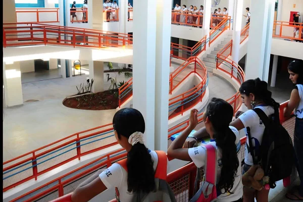 Foto colorida de estudantes em meio ao pátio da escola