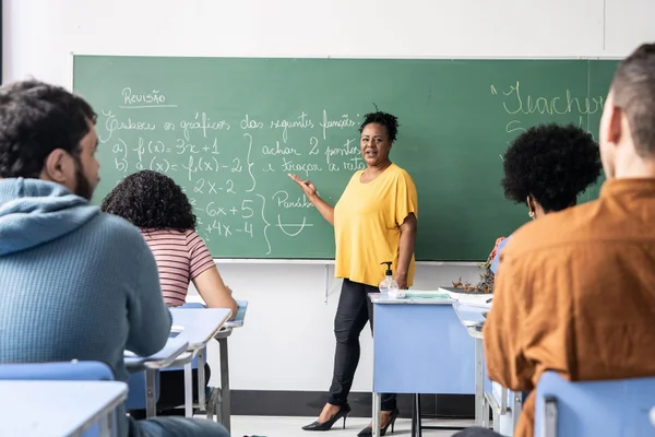 Imagem ilustrativa de professora e estudantes durante aula no Brasil jovens - Metrópoles