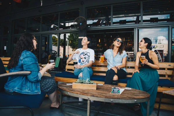 na foto vemos quatro mulheres em um bar