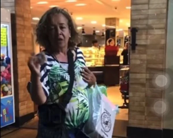 Mulher de cabelos curtos, bermuda jeans e blusa verde