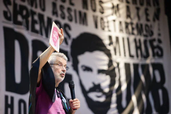 Foto colorida de homem branco com bloco em frente ao rosto de Honestino