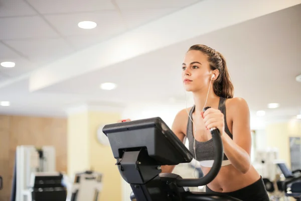 Jovem mulher realizando exercício físico em academia. Atividade física, treino na academia - Metrópoles