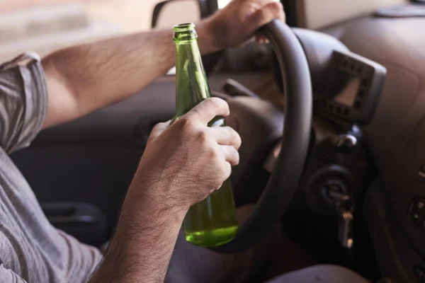 Motorista consumindo bebida alcoólica no volante. - Metrópoles