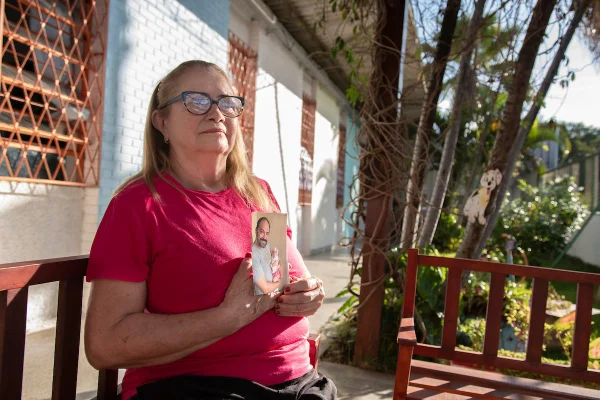Foto colorida de mulher branca de cabelo loiro e roupa rosa