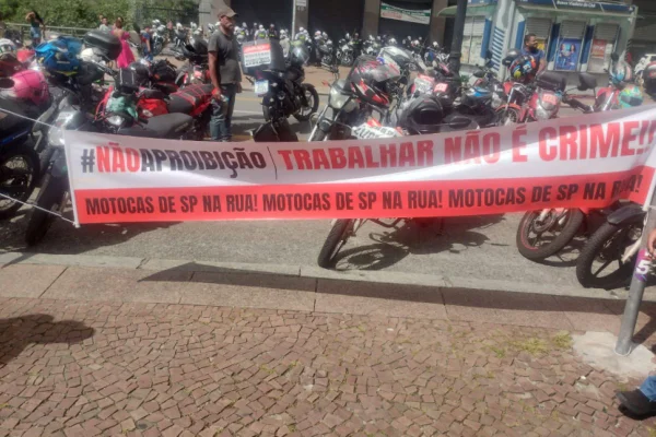 Imagens coloridas mostram protesto de motociclistas com faixa estendida em frente à Prefeitura de São Paulo