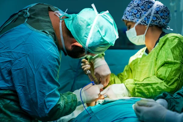 Imagem colorida de médicos realizando cirurgia - Metrópoles