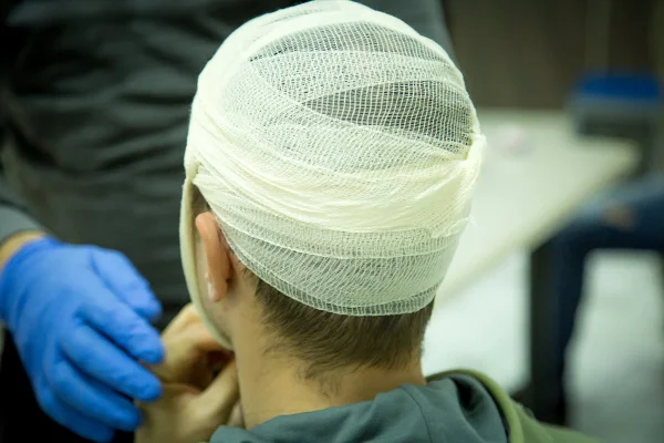 Foto colorida de homem com cabeça enfaixada - Metrópoles.