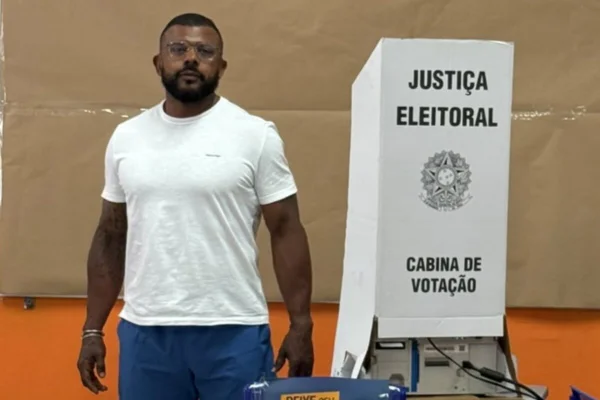 Homem negro ao lado de urna eleitoral - Metrópoles