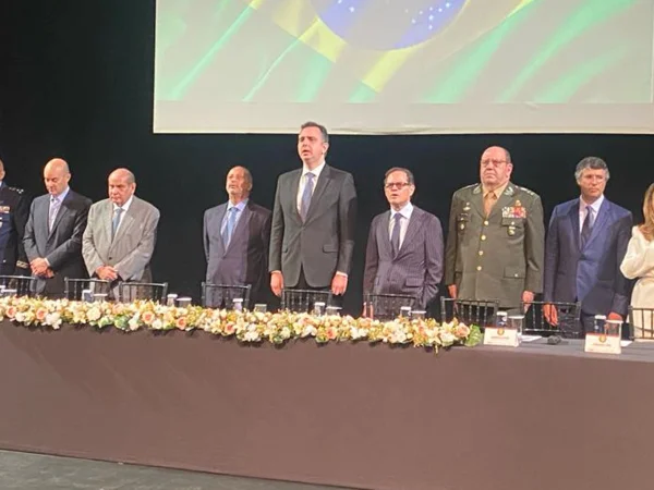 Imagem colorida mostra grupo de homens brancos em um palco