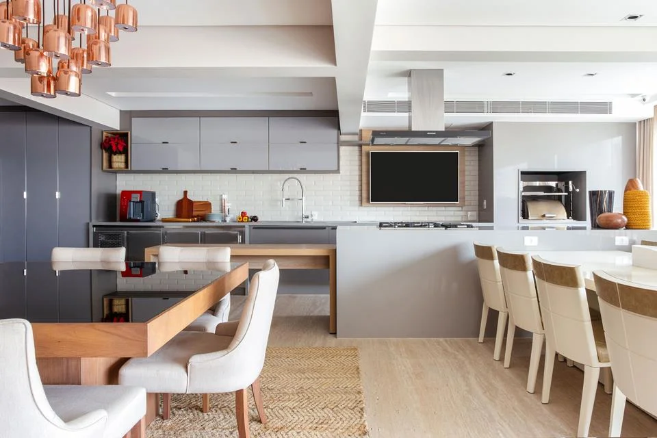 A mesa de jantar para oito pessoas sai direto da cozinha, para facilitar o acesso durante as reuniões A mesa de jantar para oito pessoas sai direto da cozinha, para facilitar o acesso durante as reuniões