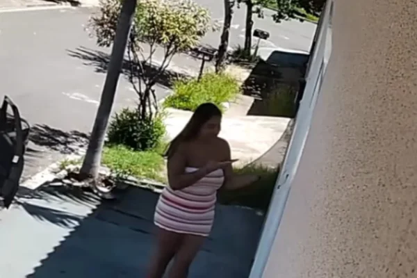 Imagem colorida de mulher entrando em casa onde foi encontrada morta. Metrópoles