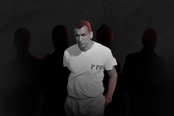 Foto preto e banco de homem branco, cabelo curto, camiseta branca e com quatro silhuetas de pessoas atrás dele - Metrópoles