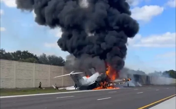 Imagem colorida de pessoas escapando de avião em chamas após acidente aéreo - Metrópoles