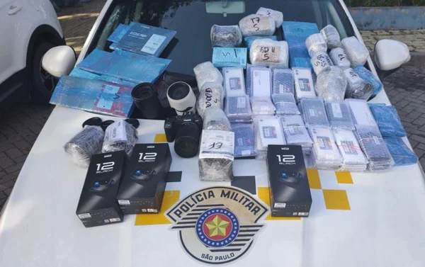 Produtos eletrônicos, como celulares, enrolados em plástico bolha ou em caixas sobre capô de carro da Polícia Militar (PM)