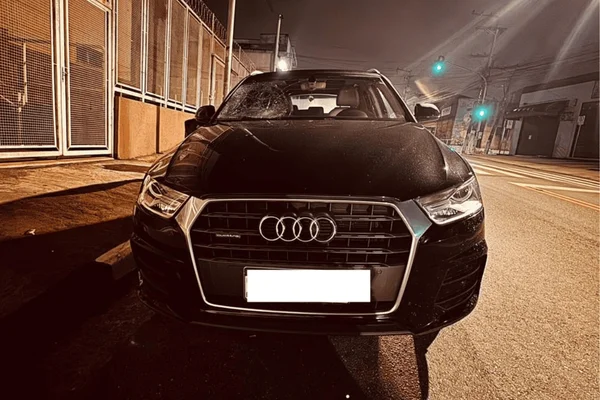 Imagem colorida de um carro preto com o vidro quebrado - Metrópoles
