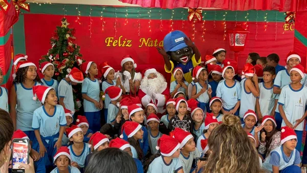 Homem vestido de Papai Noel em meio a crianças em escola do DF