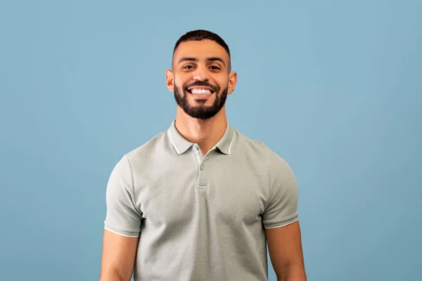 Homem de barba bem feita de camisa cinza sorridente