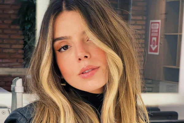 Foto colorida da atriz Giovanna Lancelotti posando para foto com o cabelo ondulado e loiro - Metrópoles