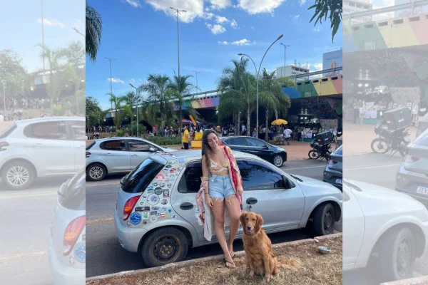 foto colorida mulher e cachorro na frente de carro em brasilia