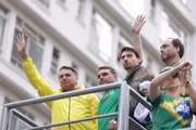 Jair Bolsonaro e seus filhos em ato em SP