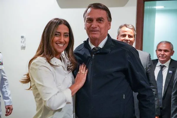 Fotografia colorida de mulher de branco com mão sobre peito de homem de preto