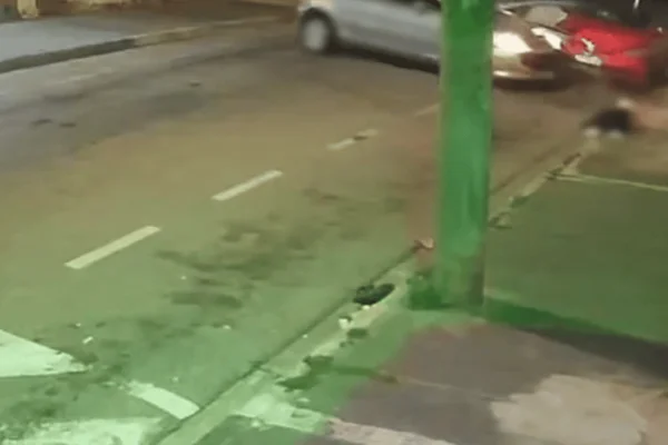 Imagem colorida de um carro prata acelerando em marcha à ré e atropelando um homem - Metrópoles