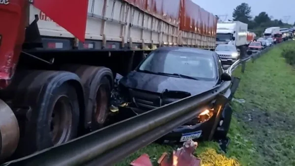 Imagem colorida de carro entre o caminhão e a mureta - Metrópoles