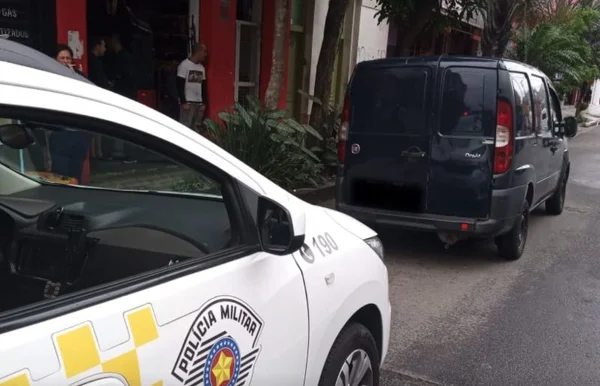 imagem colorida mostra viatura da polícia militar estacionada atrás de carro do modelo doblô, da marca fiat, em rua de são paulo - metrópoles