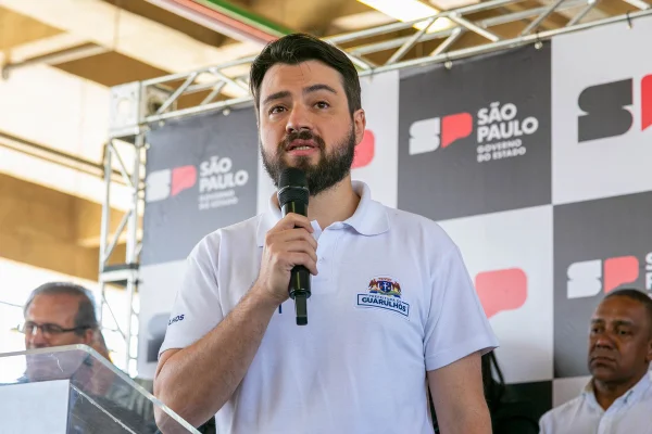 Imagem colorida mostra o prefeito de Guarulhos falando no microfone - Metrópoles