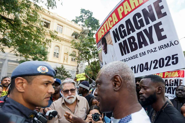 foto colorida de homem e policial se encarando em manifestação - metrópoles