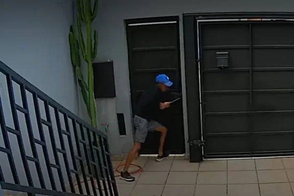 Imagem colorida mostra homem durante roubo a residência. Metrópoles