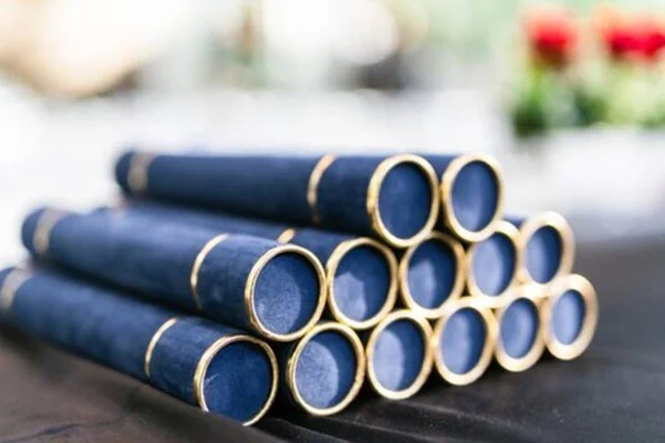 Imagem colorida de "canudos" de diplomas azuis sobre uma mesa - Metrópoles