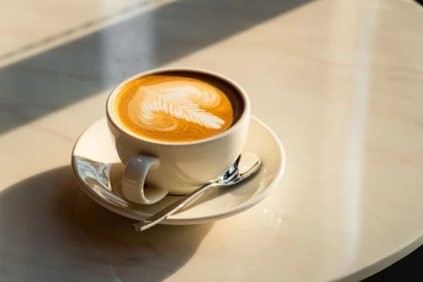 Imagem colorida de capuccino em xícara na mesa