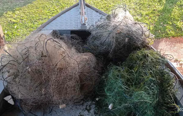 foto colorida mostra amontoado de redes de pesca sobre uma lancha da Polícia Ambiental; material foi apreendido no rio Paraná - Metrópoles