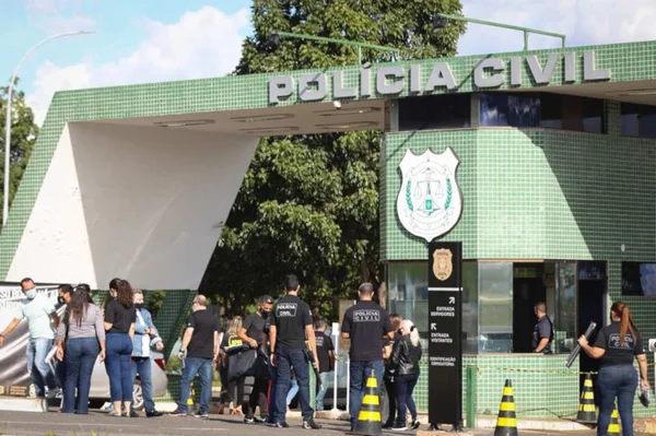 Policiais em frente à entrada da PCDF