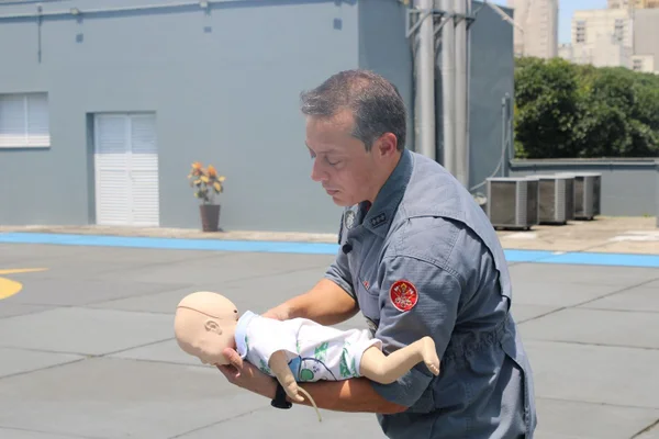 Imagem mostra bombeiro com boneco - Metrópoles