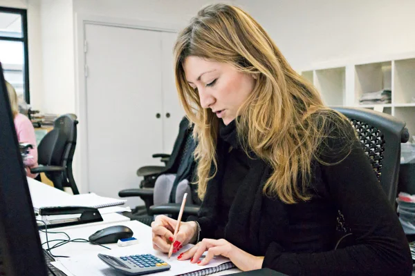 Foto colorida de mulher em escritório trabalhando - Metrópoles
