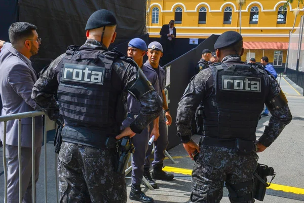 Imagem colorida mostra PMs da Rota, uniformizados, conversando em um círculo, dentro do batalhão da Rota em SP - Metrópoles
