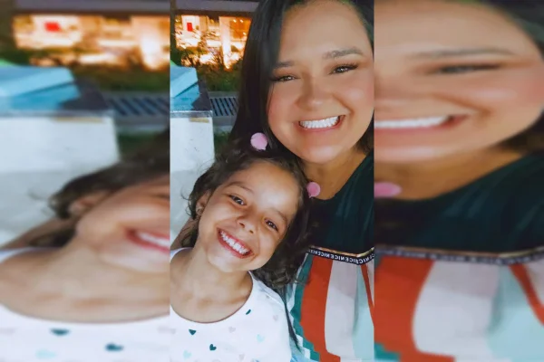 Mãe e filha paradas olhando para a câmera e sorrindo