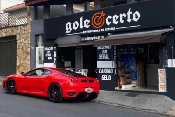 Fachada de adega de bebias, em frente a qual há uma ferrari estacionada - Metrópoles