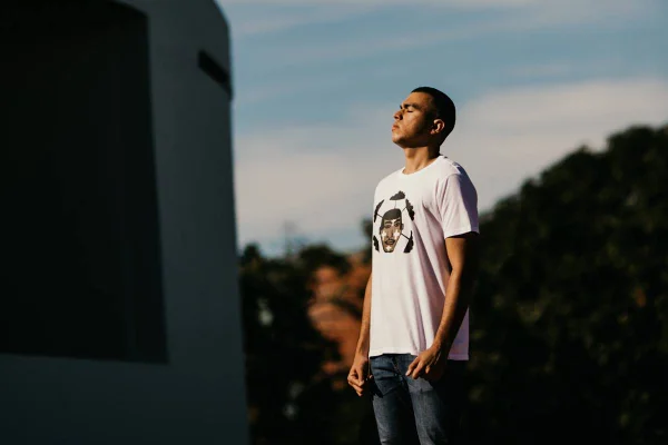 Modelo negro posa de olhos fechados em frente a monumento de Brasília