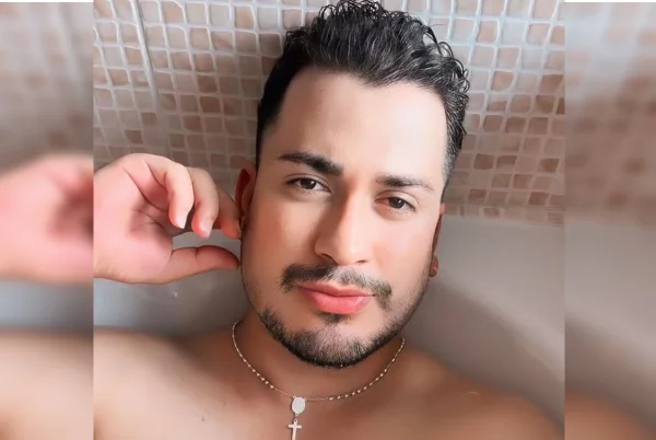 Imagem colorida do ex-modelo Douglas Almeida sem camisa, em foto com mão no rosto