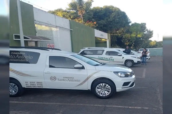 Imagem colorida de carros de funerária estacionados