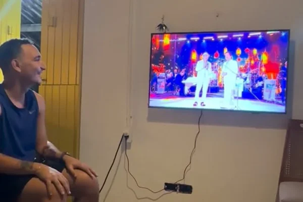 Imagem colorida do cantor João Gomes assistindo ao especial Roberto Carlos na TV - Metrópoles