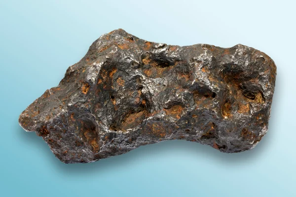 Imagem mostra um meteorito em superfície azul - Metrópoles