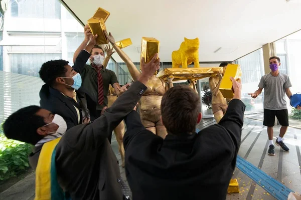 Manifestantes jogam barras de ouro pro alto e seguram bezerra dourada em protesto do MST contra suposto favorecimento a pastores em frente ao MEC - Metrópoles