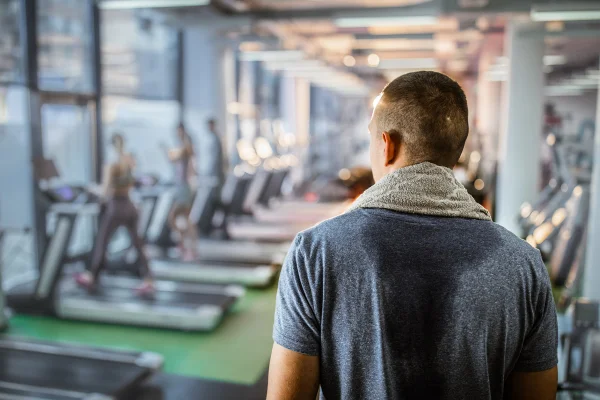 Vista traseira do atleta suado em uma academia - Metrópoles
