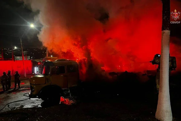 Foto colorida de bombeiros combatendo incêndio em caminhão