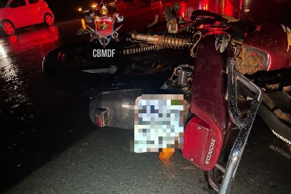 Na imagem colorida, moto vermelha caída no chão, com a placa pixalizada. Motociclista foi atropelado e morreu - Metrópoles
