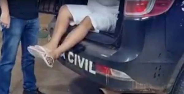 Homem de chinelos saindo de viatura da Polícia Civil